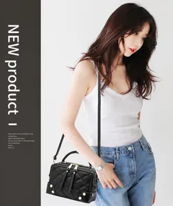 Borsa a cuscino vintage trapuntata nera con borchie dorate indossata da una modella