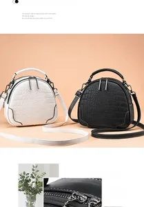 Close-up of crocodile pattern texture on semi-circular crossbody bag with zip detail