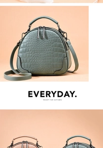 Detail view of crocodile pattern shell handbag with dual zippers and leather handle