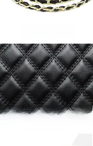 Detail of black quilted PU leather texture and gold metal chain strap on crossbody bag