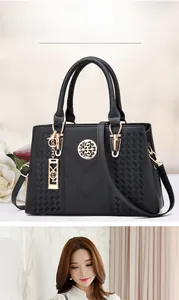 Close-up of black litchi pattern leather handbag with gold metal hardware and side texture