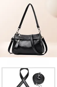 Detail of black soft leather crossbody bag showing dual interchangeable shoulder straps