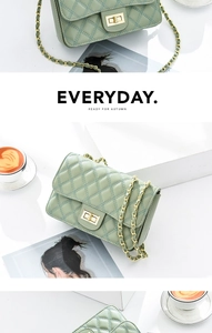Detail of light green quilted crossbody bag with gold chain strap and twist-lock