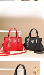 Detail view of stylish red and black faux leather handbags with V-stitch and woven textures