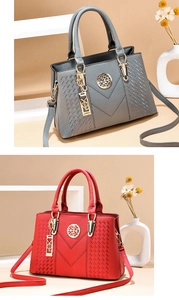 Detail of red and grey lychee leather handbags with V-shaped stitching and metal logo