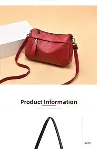 Detail of red leather crossbody bag showing natural texture and multi-zipper pockets
