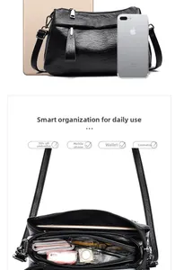 Detail view of black multi-zip crossbody bag showing internal compartments and large capacity