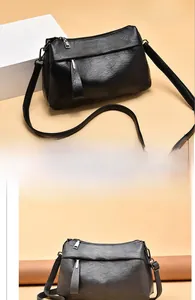 Close-up of black litchi texture leather shoulder bag with metallic zipper details