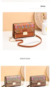 Detailed embroidery floral pattern on PU leather crossbody bag with metal rivets