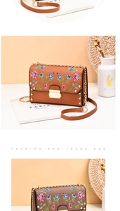 Macro shot of floral embroidery and gold rivets on a caramel brown PU leather handbag