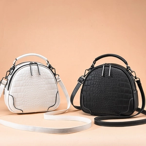 Minimalist round crocodile pattern handbag in white and black with top handle and strap