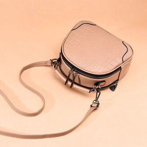 Beige crocodile embossed round crossbody bag with double zippers and top handle
