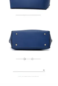 Détail du sac à main bleu foncé montrant la texture matelassée et les pieds en métal doré
