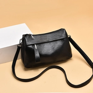 Minimalist black pebbled leather crossbody bag for women with decorative zippers