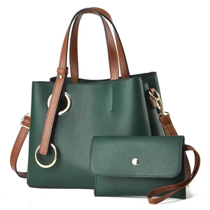 Detail view of dark green lychee textured tote bag set with golden ring hardware and strap