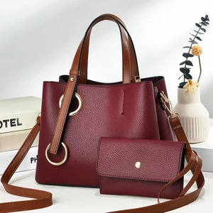 Detail of burgundy lychee pattern tote and flap wallet set with gold ring hardware