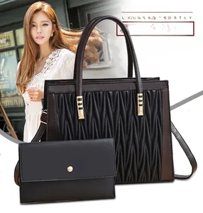 Detail of black quilted tote bag and matching wallet set with elegant gold hardware