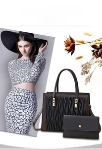 Detail of black pleated crossbody bag with gold hardware and matching long flap wallet