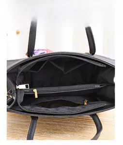 Internal view of the black tote bag showing multiple compartments and golden zippers