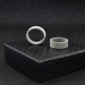 Minimalist silver mesh rings in an industrial style displayed on a black leather box