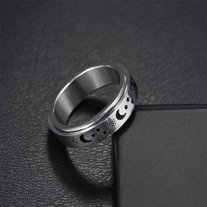 Brushed stainless steel spinner ring featuring engraved sun, moon, and stars patterns