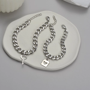 Minimalist stainless steel couple bracelets with heart lock and key pendants on stone