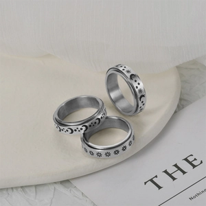 Three-piece stainless steel spinner rings set with sun moon star and daisy engravings