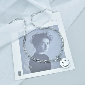 Collier minimaliste en acier inoxydable avec pendentif smiley sur magazine