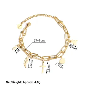 Detail of gold double-layer chain bracelet featuring heart, bear and cross charms