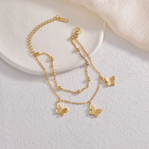 Bracelet double rang en acier inoxydable doré avec trois breloques papillons givrées et billes