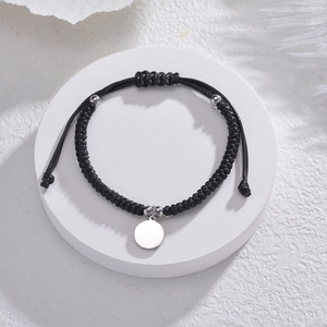 Bracelet cordon tressé noir avec pendentif rond en acier inoxydable sur fond blanc élégant