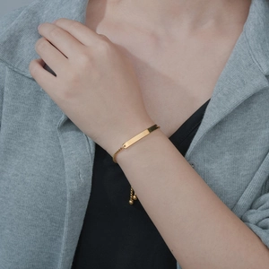 Gold minimalist adjustable bar bracelet with delicate chain shown on a model wrist