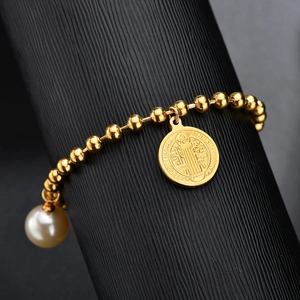 Bracciale in acciaio dorato con medaglia San Benedetto e perla su supporto nero