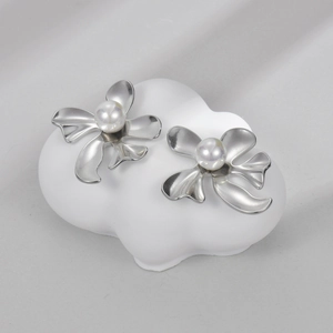 Minimalist silver flower earrings with pearls on a cloud-shaped display stand