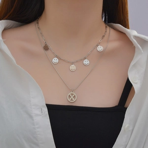 Double-layered stainless steel necklace with smiley face charms and an X-shaped pendant