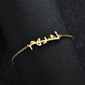 Gold stainless steel bracelet with custom Arabic calligraphy nameplate on black stand