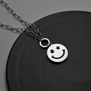 Collier argenté poli avec pendentif sourire aux yeux d'étoile sur base noire