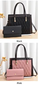 Detail of pleated tote bags and matching wallets in black and pink with gold hardware