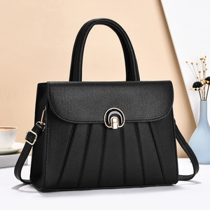 Détail du sac en cuir grainé noir avec plis accordéon et fermoir métallique doré
