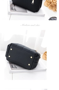 Detail of black lychee-textured handbag showing golden metal feet and premium stitching