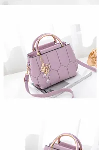 Detail of purple PU leather bag with gold handles and geometric stitching on a magazine