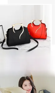 Détail des poignées dorées en forme de chat et du cuir PU sur des sacs à main tendance