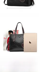 Detalle del bolso tote de cuero negro con costuras blancas y dimensiones de medida