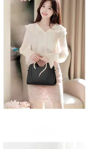 Détail d'un sac à main en cuir noir avec ornements dorés et poignée métallique chic