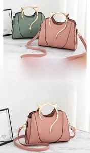 Détail de poignées dorées en forme de chat sur sacs à main en cuir rose et vert foncé