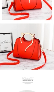 Détail du sac à main rouge en similicuir avec poignée métallique unique en forme de chat