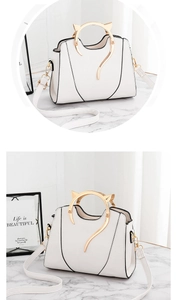 Détail du sac à main en cuir PU blanc avec poignées dorées en oreilles de chat et décor chat