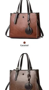Detalle del bolso tote de cuero color caramelo con herrajes dorados y textura grabada