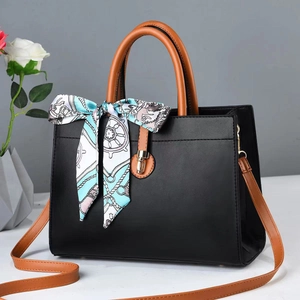 Minimalist black tote bag with brown handles and a nautical silk scarf accent
