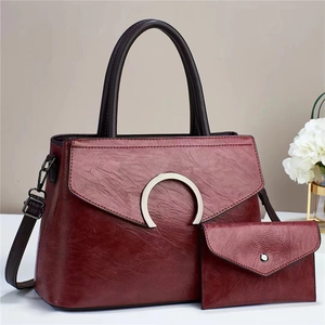 Macro shot of burgundy faux leather texture and gold C-shaped metal buckle on the handbag